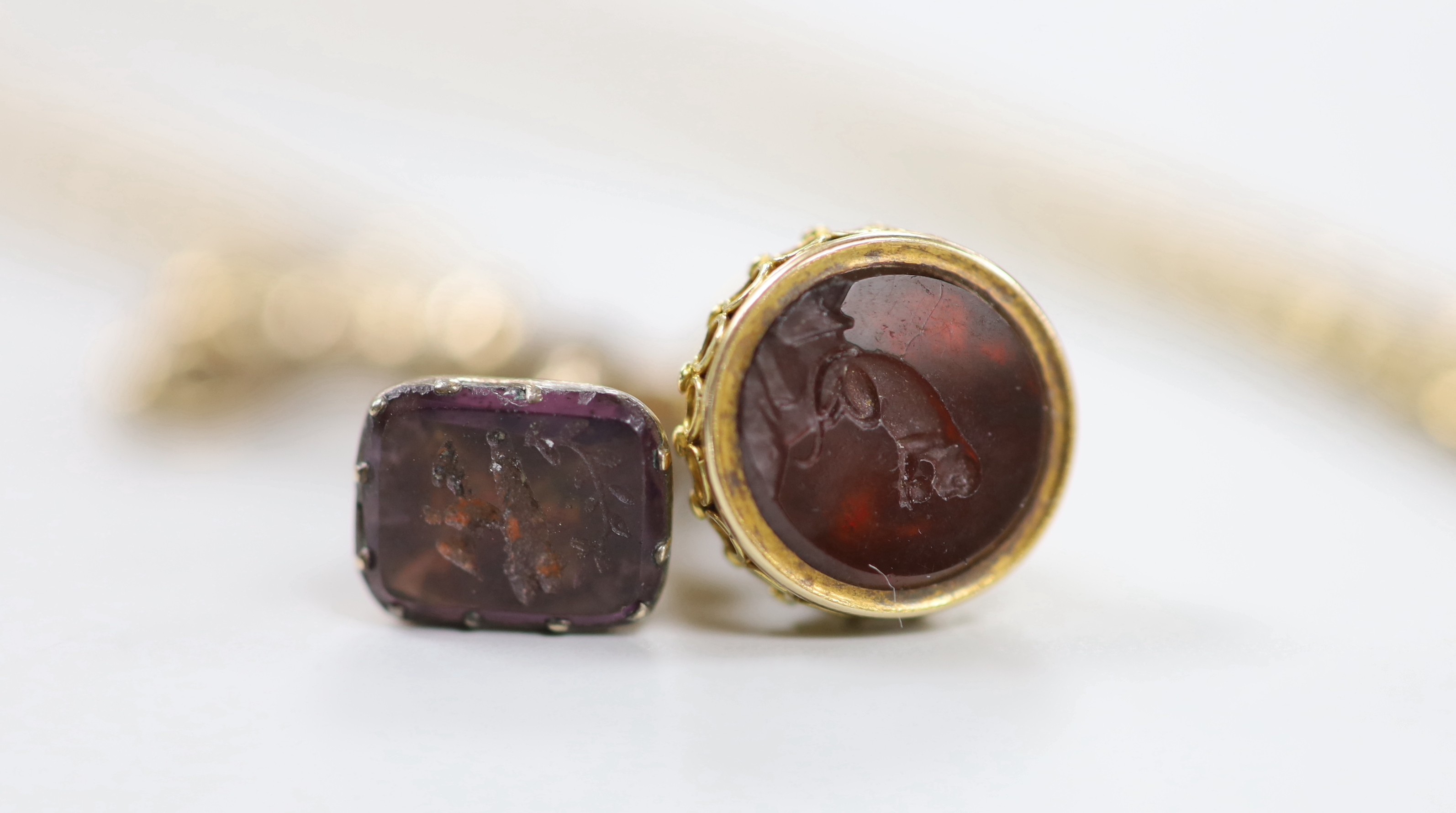 A late Victorian 9ct guard chain, hung with two yellow metal overlaid seals, with amethyst or red carnelian? carved matrices, chain length 164cm, 32.9 grams.